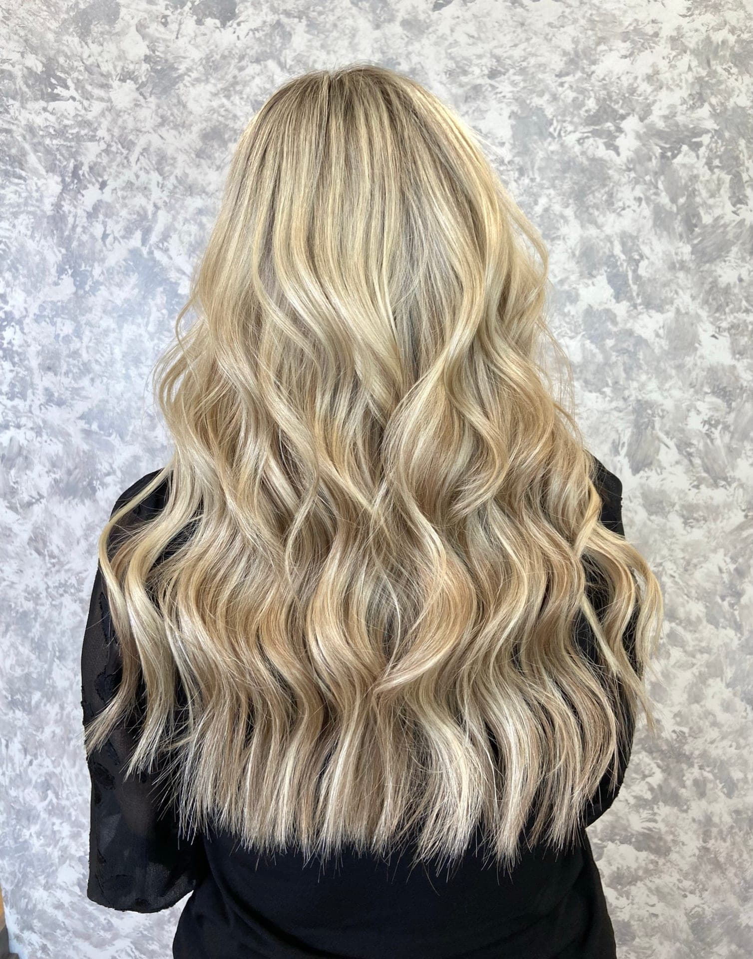 Long platinum blonde hand tied extensions falling in soft waves