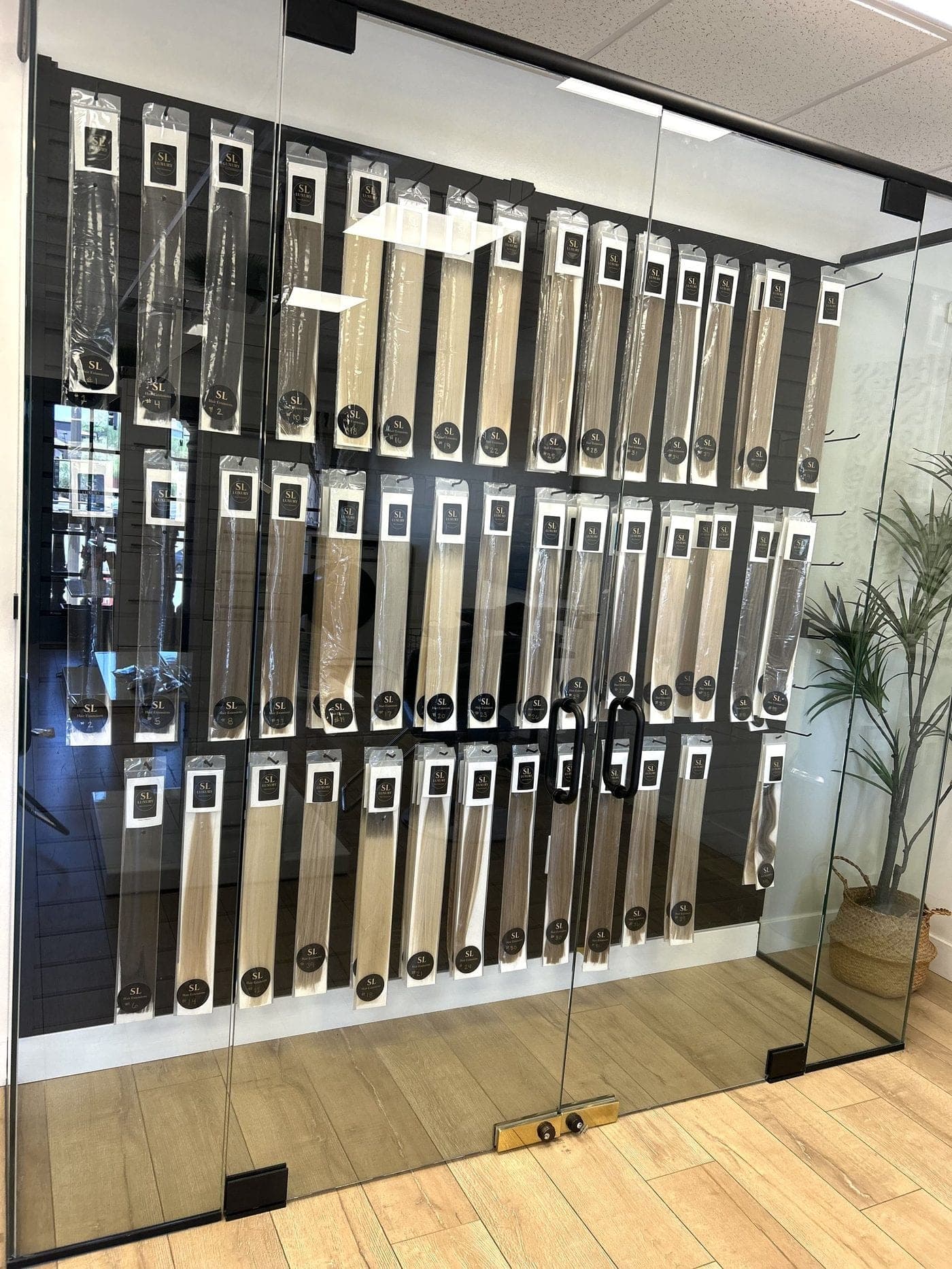 Signature Hair on site — color-matched wefts in the glass display case at The Salon Lounge